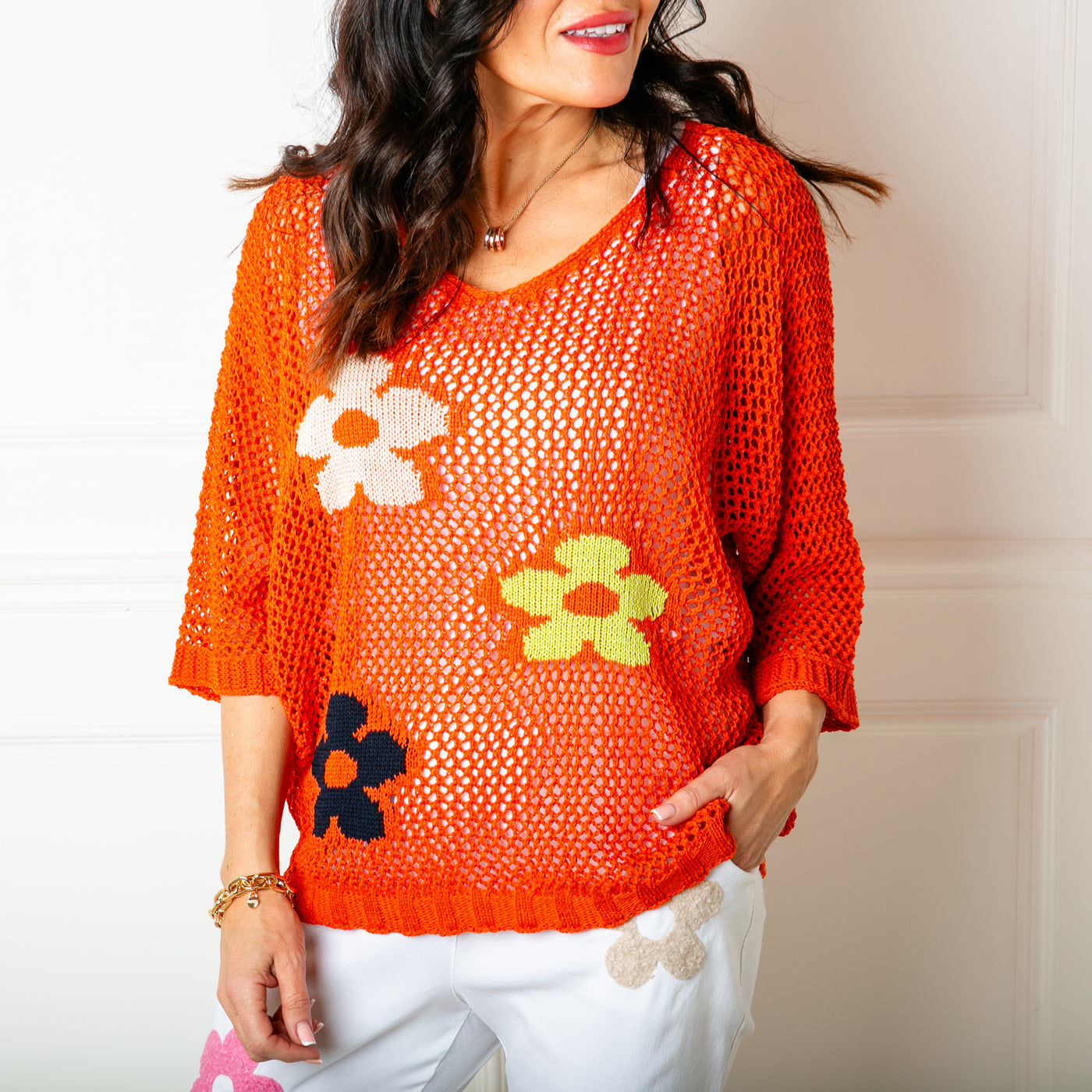 The orange crochet Flower Top featuring a bold vibrant flower pattern across the front